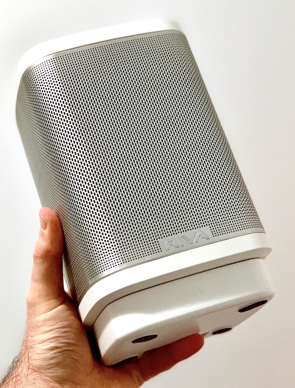 Picture of Riva Concert smart speaker being held up in one hand.