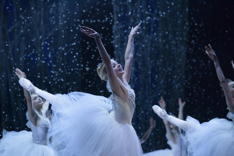 Blonde dancer Dawn Atkins in a high arabesque and bright smile dances Nutcracker's snow scene.