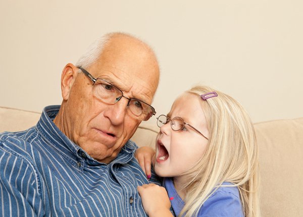 girl yelling in her grandfather's ear