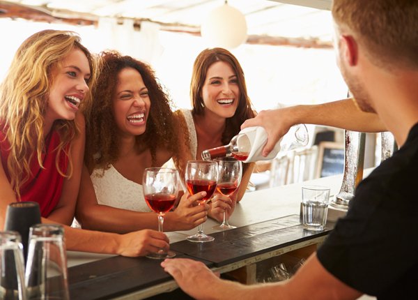 women drinking wine at a bar