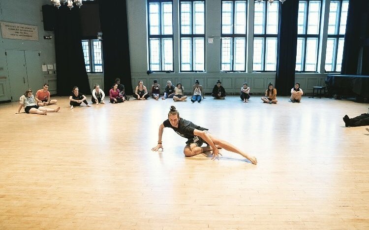 Dancer Isaac Iskra dances in a classroom, while the other students watch