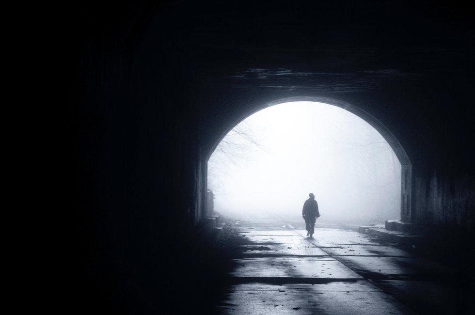 Empty, dark outdoor space with a single person walking