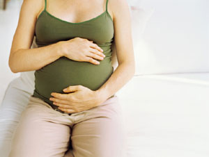 woman with her hands on her pregnant stomach