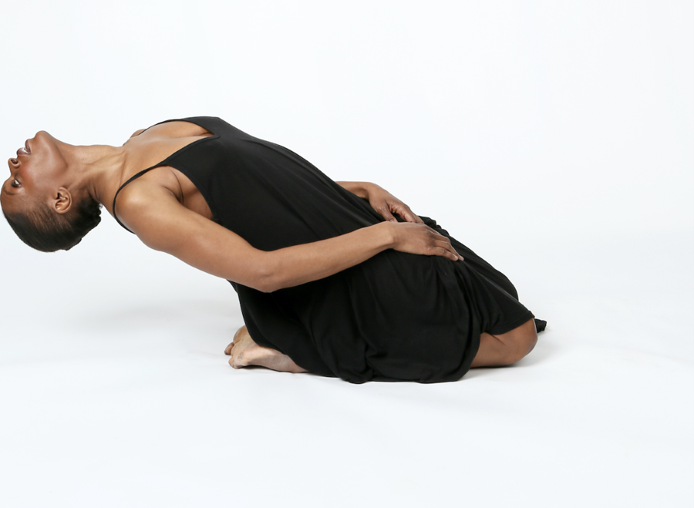 Okwui Okpokwasili on her knees leaning back