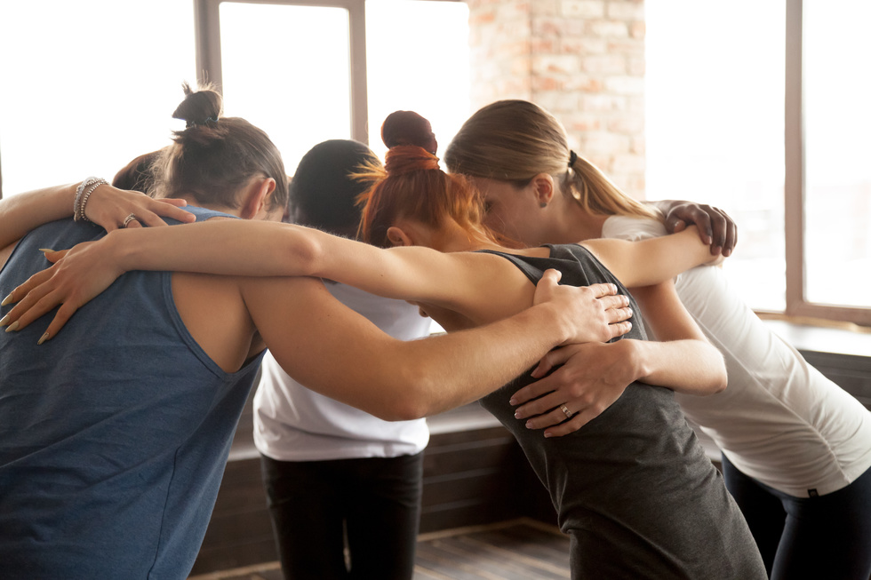 Dancers embrace each other in a group