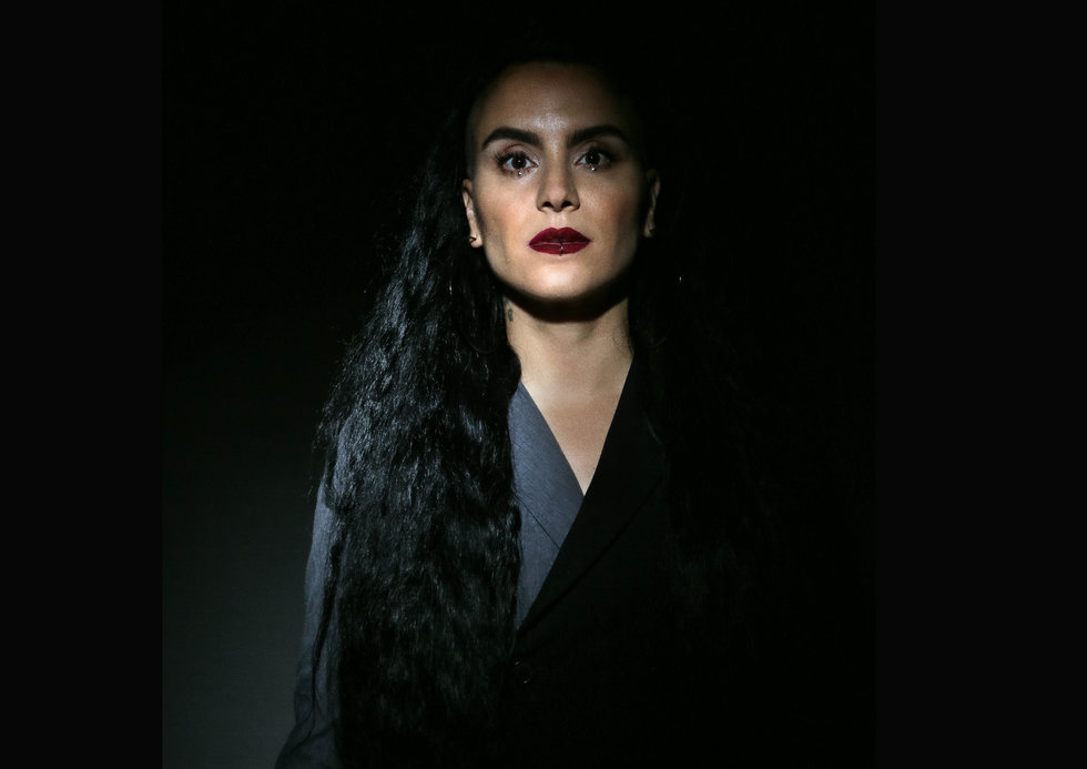 Sonya Tayeh stares into the camera, shining through the dark