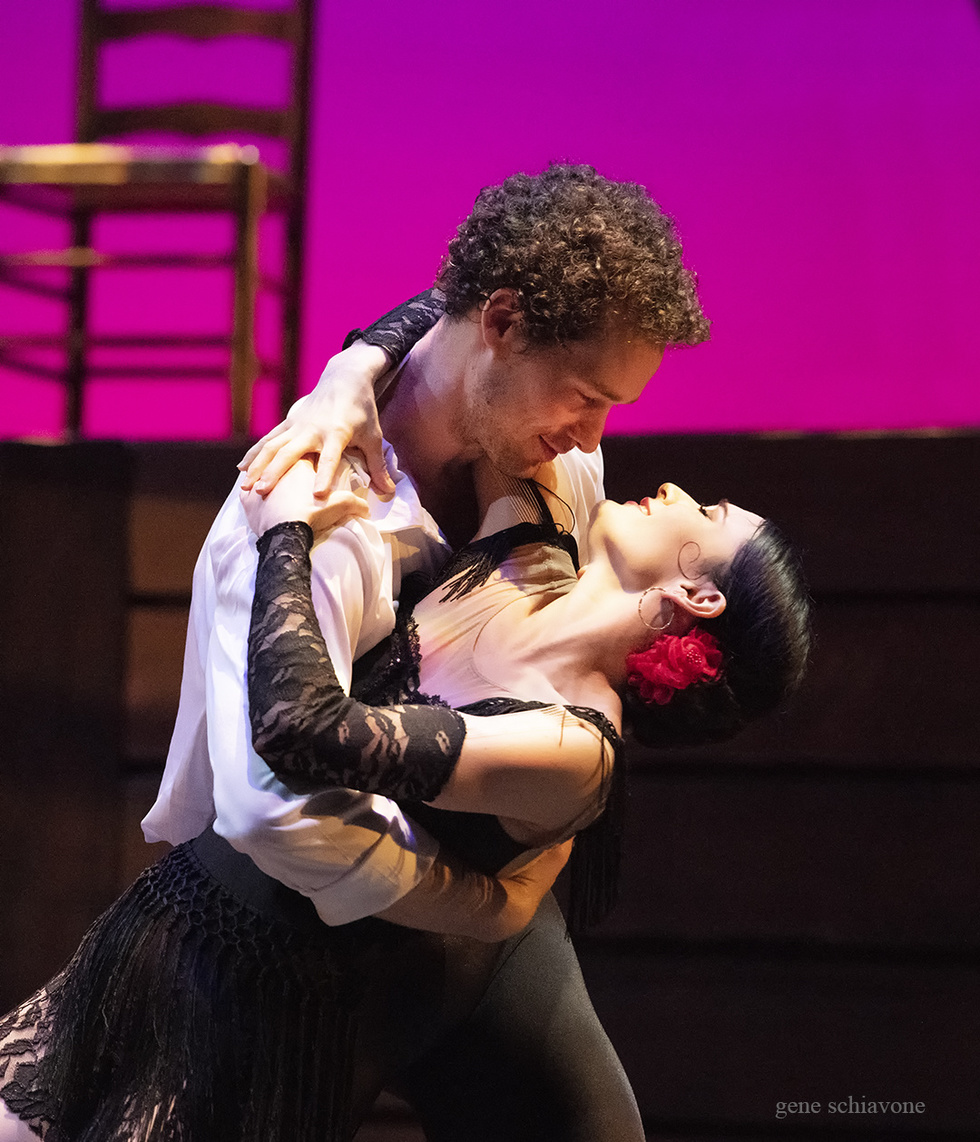 Cory Stearns and Sarah Lane embrace onstage. Sarah wears a short, black, lacy dress and a rose in her hair.