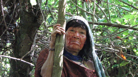 Noemi Vagus, an Ashaninka shaman, standing in front of an Ayahuasca vine in the Peruvian Amazon