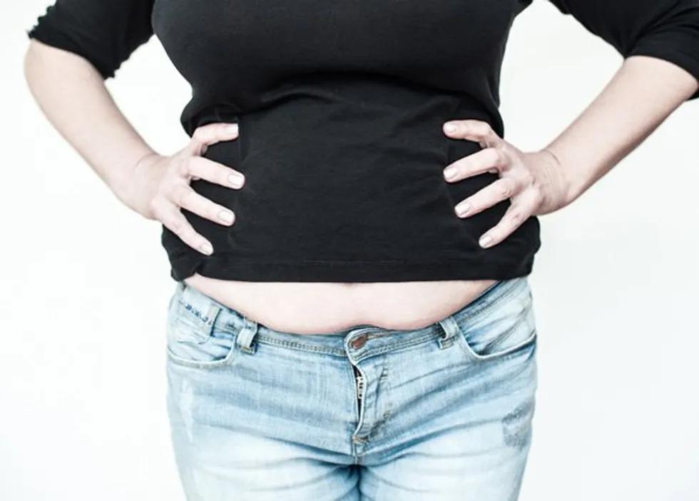 Overweight woman in jeans, woman with a fat upper pubic area in