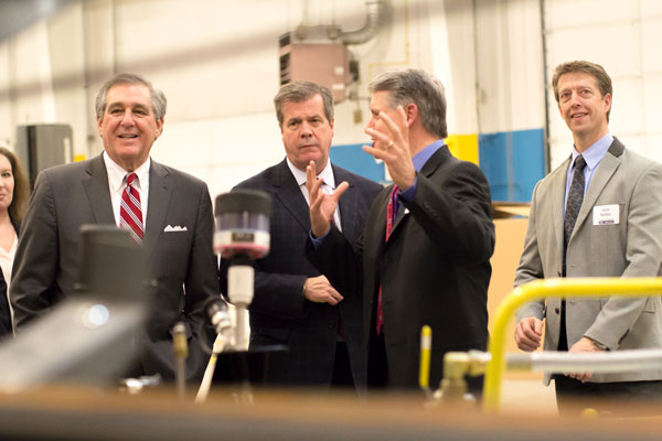 Des-Case President and CEO Brian Gleason explains the process of manufacturing fluid handling equipment to Jerry Abramson, left, deputy assistant to the President of the United States and director of intergovernmental affairs, and his entourage in a 