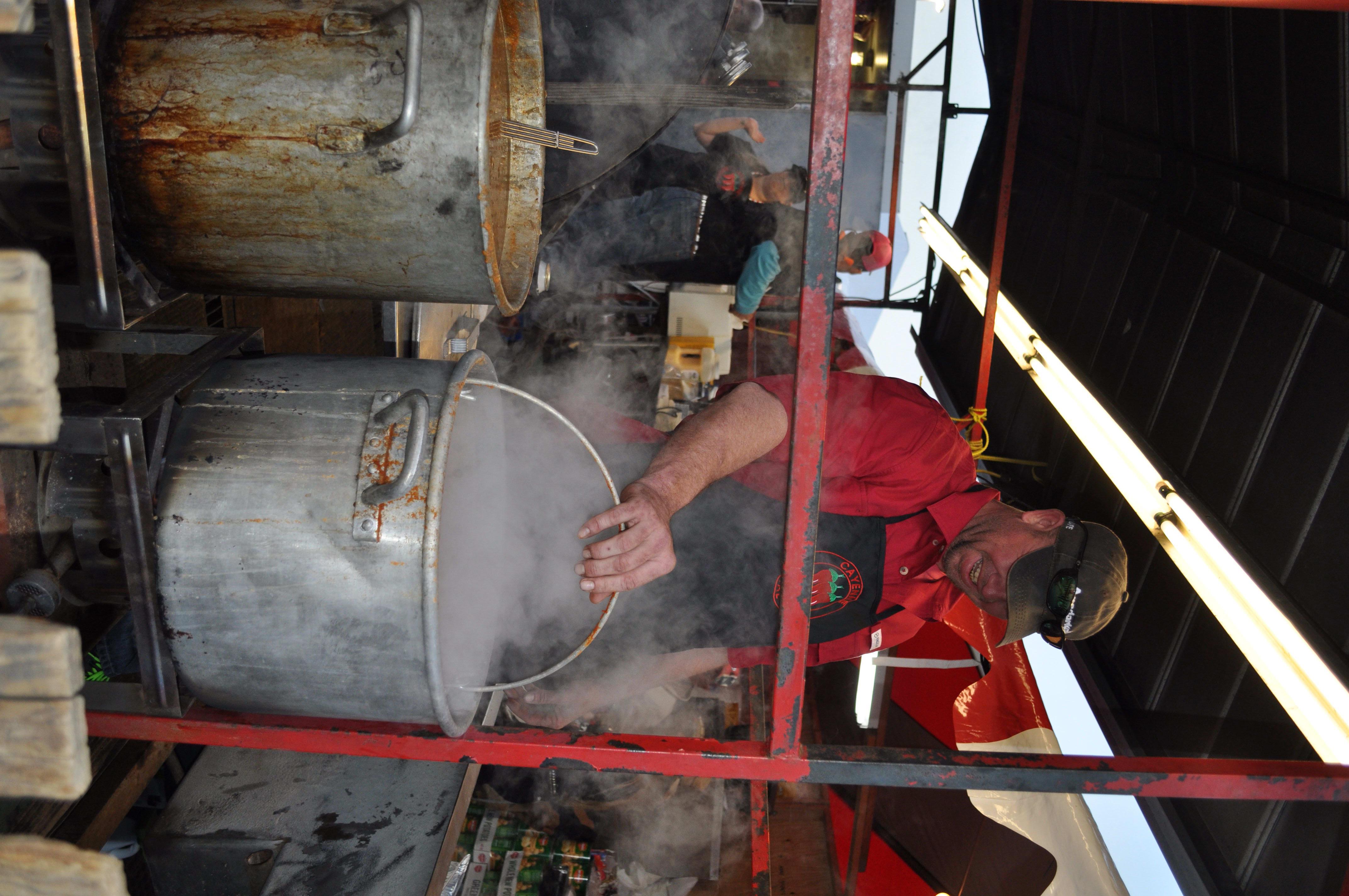 Bret Simmons handles a vat of potatoes spiced with crawfish seasoning at  the Cayenne Social Club party tent. - CultureMap Houston