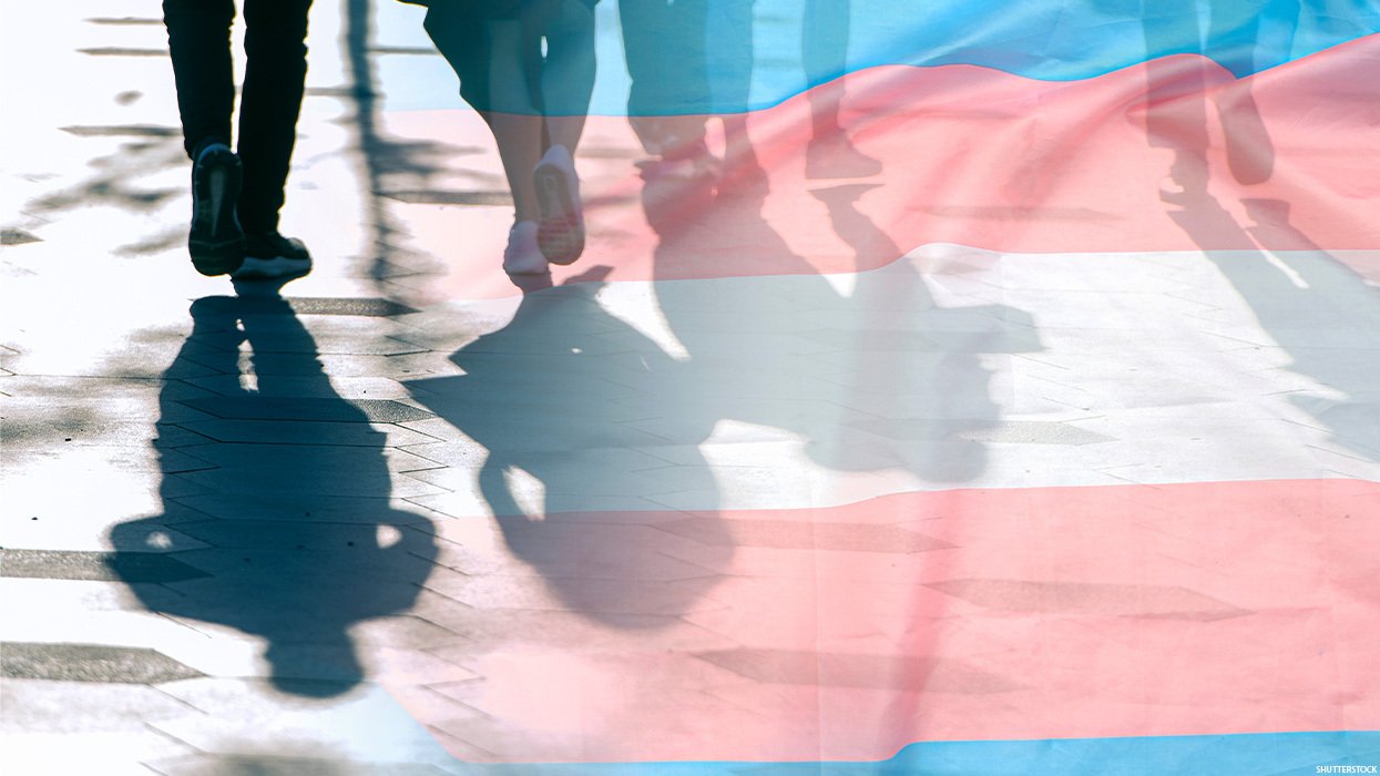 People walking along a path with a blended-in trans pride flag