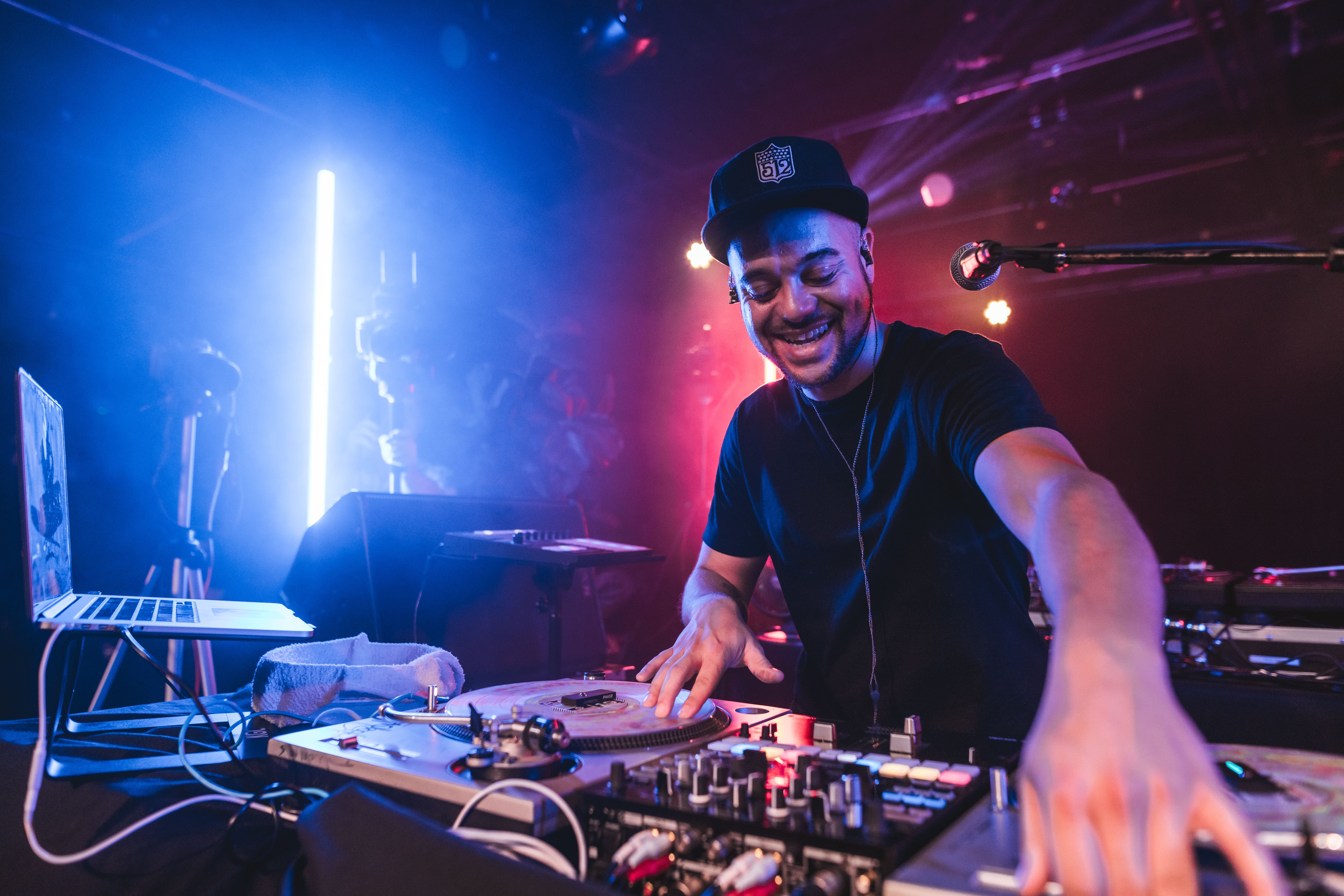 DJ performing with mixing equipment