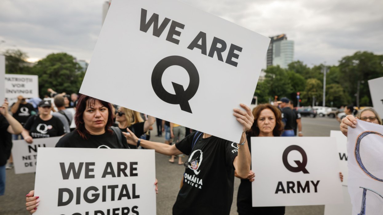 People holding QAnon Signs