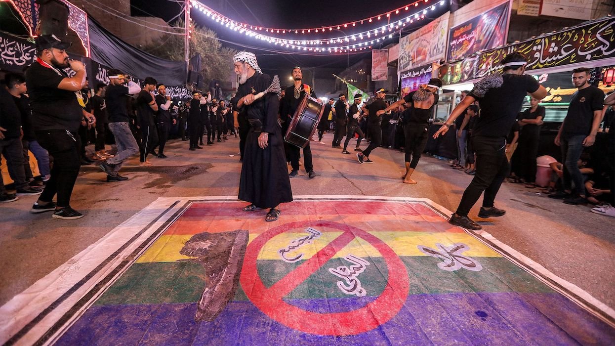 Shiite Muslim devotees self-flagellate over an unfurled banner on the ground depicting the Pride rainbow flag defaced with a boot and the Arabic slogan "no to homosexual society," in Iraq