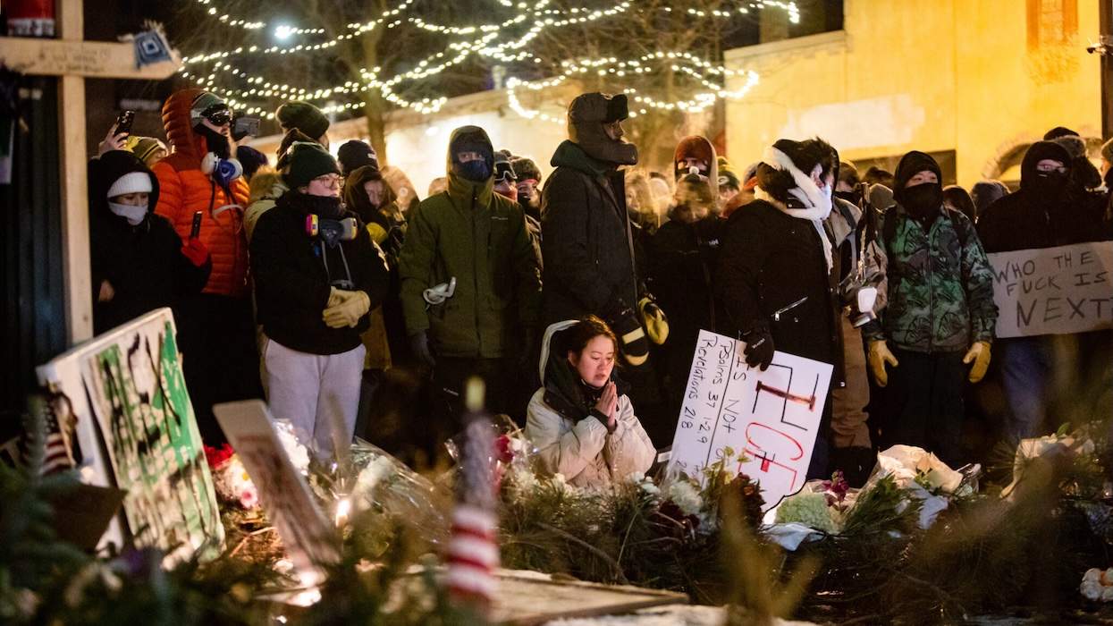 ​A woman kneels and prays as hundreds gather around a growing memorial site at 26th Street and Nicollet Avenue, where federal agents shot and killed a 37-year-old Alex Pretti Saturday, Jan. 24, 2026 earlier in the day. 
