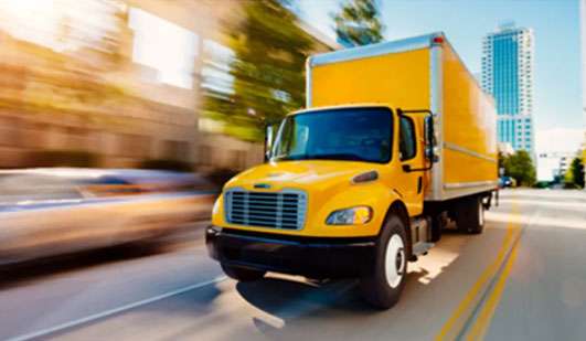 Penske medium duty box truck driving through city streets