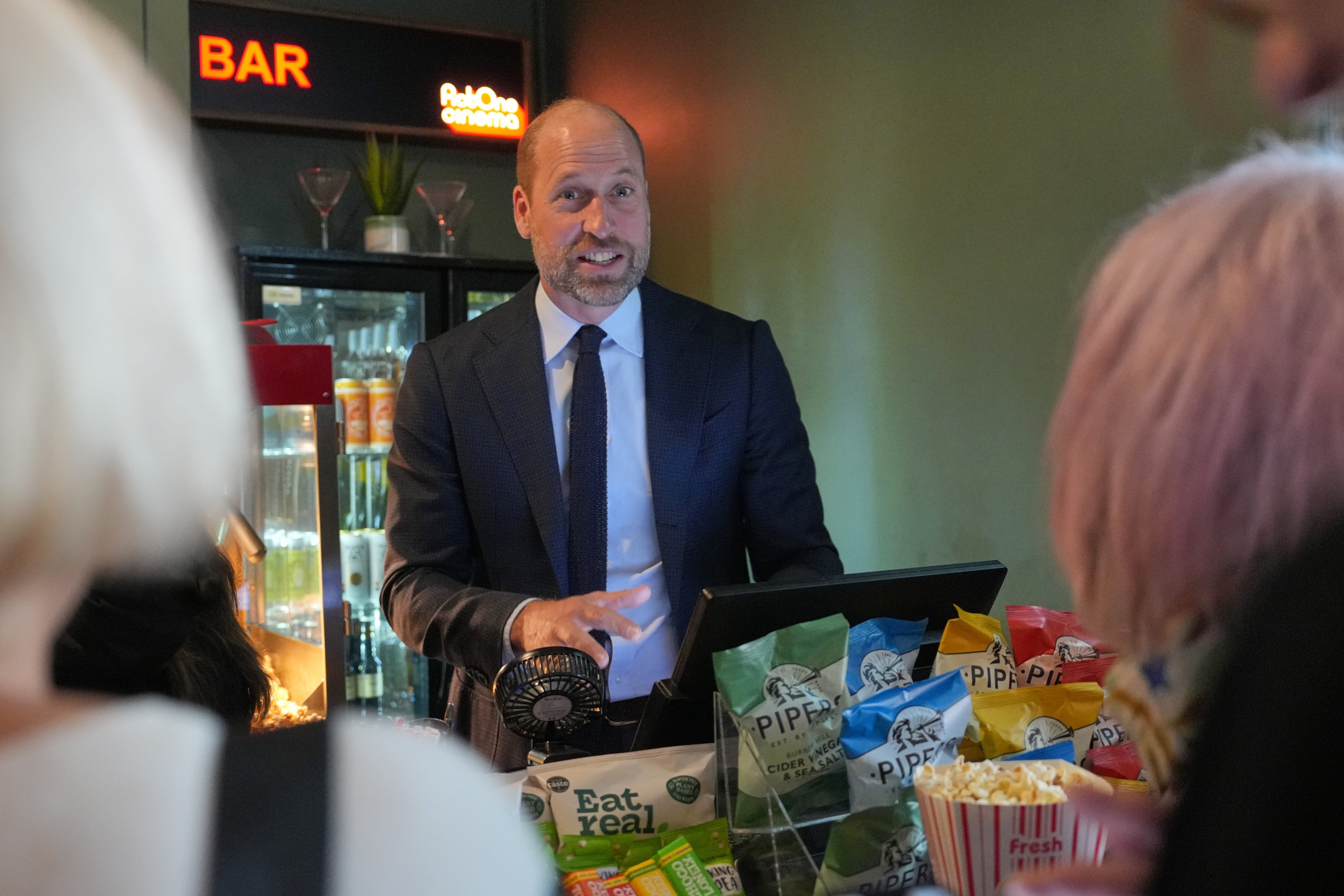 Prince William dishes out popcorn as he jokes with filmgoers ahead of Tom Cruise reunion