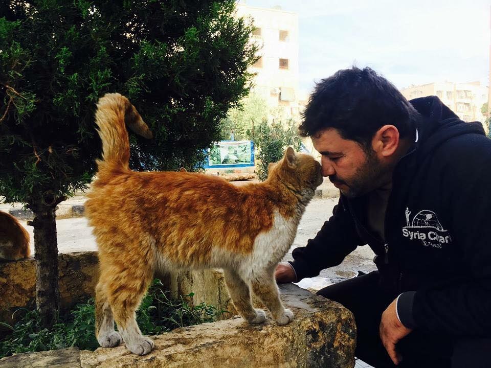Cat man of Aleppo kisses cat
