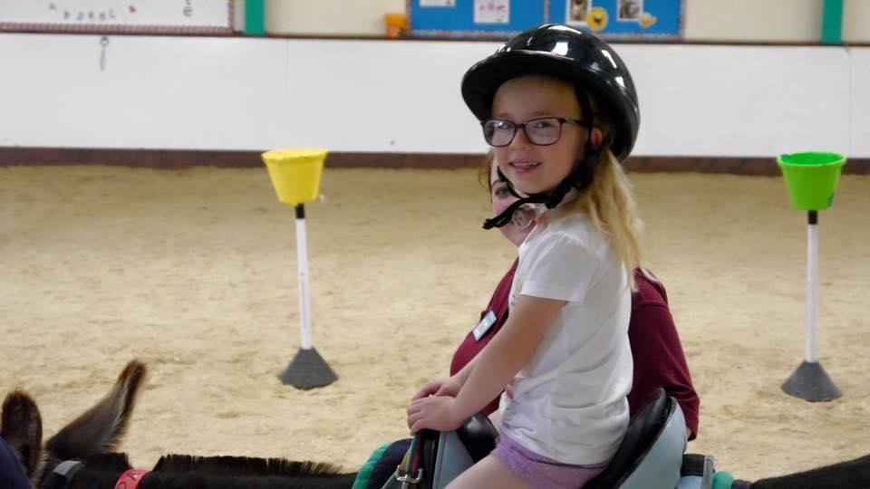 Girl riding therapy donkey at The Donkey Sanctuary in Birmingham